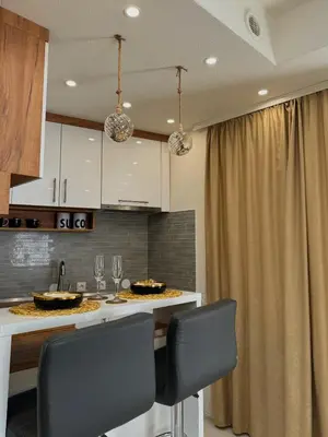 a kitchen with a counter with chairs and a sink at Stan na dan sa dzakuzijem om relax in Prijedor
