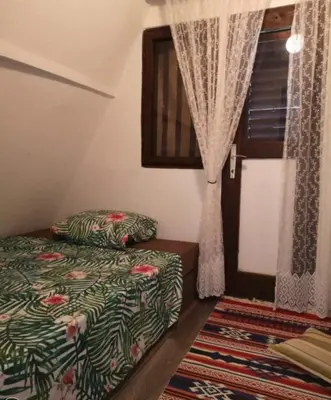 a small bedroom with a bed and a window at Pine Oasis in Zavidovići
