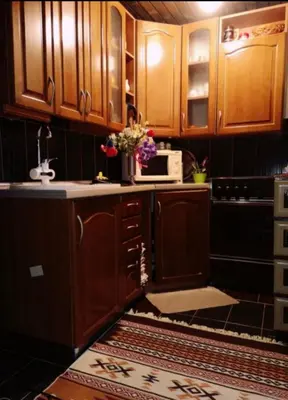 a kitchen with wooden cabinets and a counter top at Pine Oasis in Zavidovići