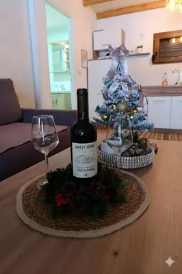 a bottle of wine and a christmas tree on a table at Sweet Home Visoko FREE PARKING, AC, RENT A CAR in Visoko