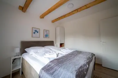 a bedroom with a bed with white sheets at Sweet Home Visoko FREE PARKING, AC, RENT A CAR in Visoko