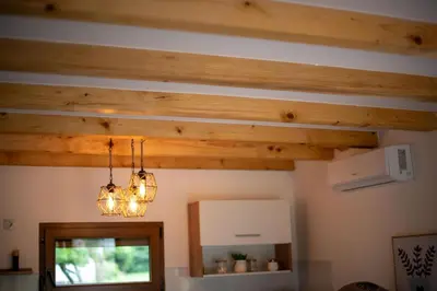 a room with wooden ceilings and lights and a mirror at Sweet Home Visoko FREE PARKING, AC, RENT A CAR in Visoko