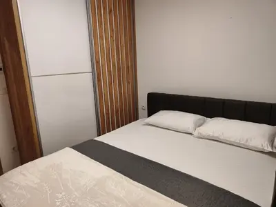 a bed with two pillows on it in a room at Apartmani Sanja in Teslić