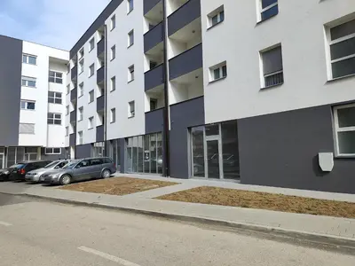 a building with cars parked in a parking lot at Apartmani Sanja in Teslić