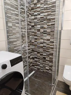 a bathroom with a shower with a toilet and a glass door at Apartmani Sanja in Teslić
