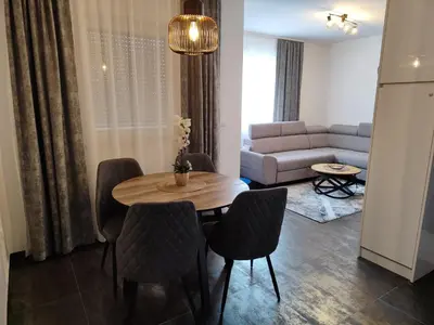 a living room with a table and chairs and a couch at Apartmani Sanja in Teslić