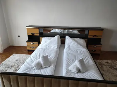 a bed with two white pillows and a dresser at REA Home Visoko in Visoko