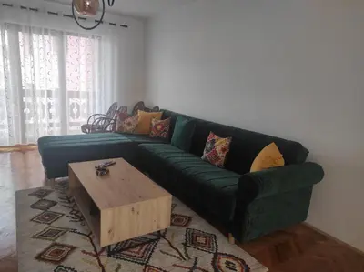 a green couch in a living room with a coffee table at REA Home Visoko in Visoko