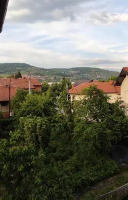 a group of trees with buildings in the background at REA Home Visoko in Visoko