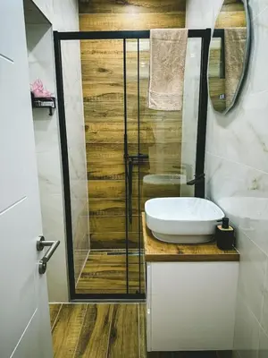 a bathroom with a sink and a glass shower at Apartman Zdravko in Tomislavgrad
