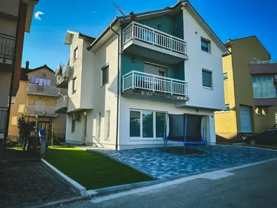 an apartment building with a playground in front of it at Apartman Zdravko in Tomislavgrad