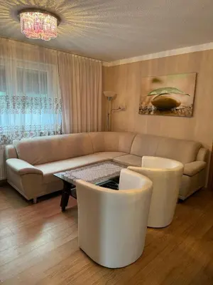 a living room with a couch and a table and chairs at Apartment Deluxe Holiday in Bihać