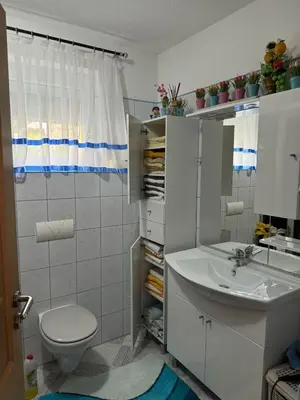 a bathroom with a white toilet and a sink at Apartment Deluxe Holiday in Bihać