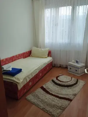 a small bedroom with a bed and a rug at Apartman Unac in Drvar