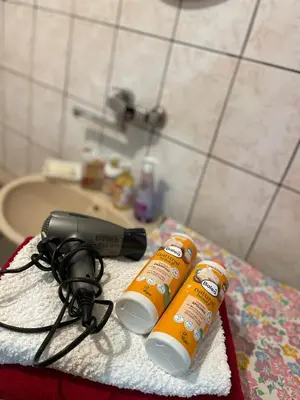 a bathroom counter with two bottles of hair products and a blow dryer at Apartment Old Town Visoko in Visoko