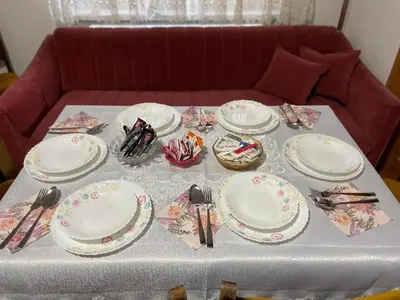 a table with plates and utensils on it at Apartment Old Town Visoko in Visoko