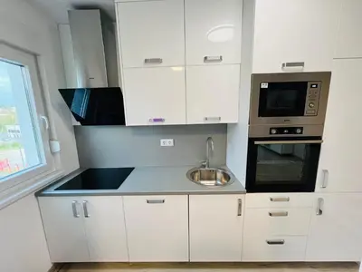 a white kitchen with a sink and a microwave at Happy Dreams Oasis Cazin, Modernes Apartment 60m2, WiFi & Balkon in Cazin