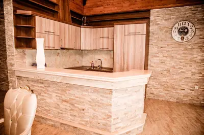 a kitchen with a sink and wooden cabinets at Lux Villa Emina in Tuzla