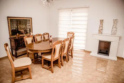 a dining room with a table and chairs and a fireplace at Lux Villa Emina in Tuzla