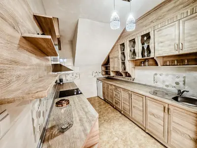 a kitchen with wooden cabinets and a sink at Lux Villa Emina in Tuzla