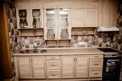 a kitchen with wooden cabinets and a sink at Lux Villa Emina in Tuzla