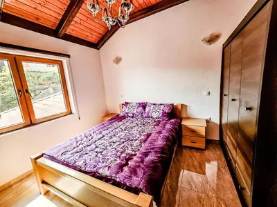 a bedroom with a purple bed with a window at Lux Villa Emina in Tuzla