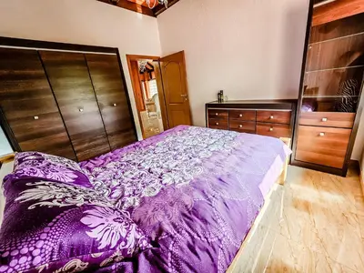 a purple bed in a bedroom with wooden cabinets at Lux Villa Emina in Tuzla