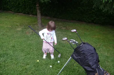 a little girl playing golf in the yard at Resort Čokori in Banja Luka