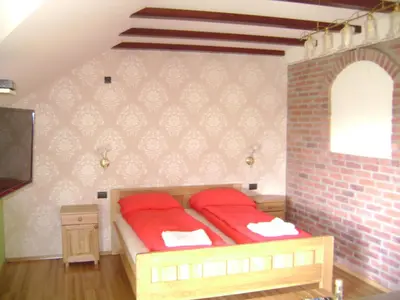 a bedroom with a bed with red pillows on it at Resort Čokori in Banja Luka