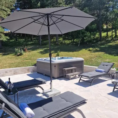 an umbrella and two chairs and a hot tub at Holiday Home Gredina in Livno