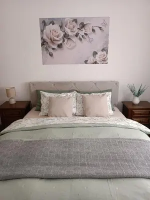 a bedroom with a bed with pink roses on the wall at Apartman Centar in Modriča