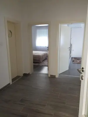 a bedroom with a bed and a door leading to a bedroom at Apartman Centar in Modriča
