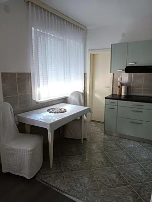 a kitchen with a table and a chair and a counter at Apartman Centar in Modriča