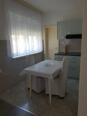 a kitchen with a table and chairs in a kitchen at Apartman Centar in Modriča