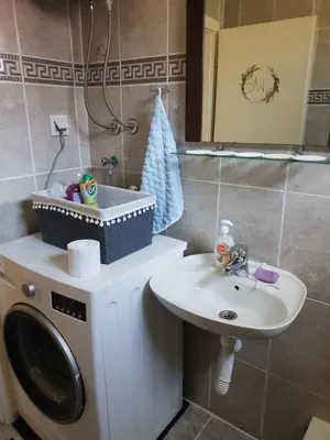 a bathroom with a washing machine and a sink at Apartman Centar in Modriča