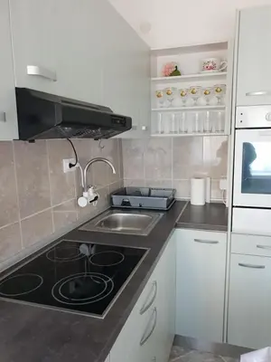 a kitchen with a sink and a stove top oven at Apartman Centar in Modriča