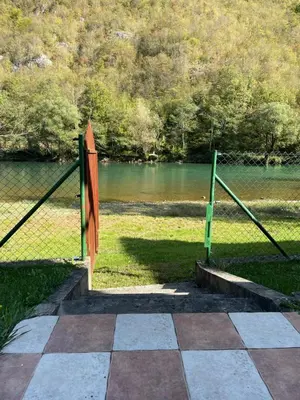 a gate in a field next to a body of water at 069 Riverside Vikendica - Banja Luka in Rekavice