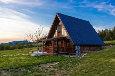 a log cabin with a solar roof on a hill at Village house Iva in Livno