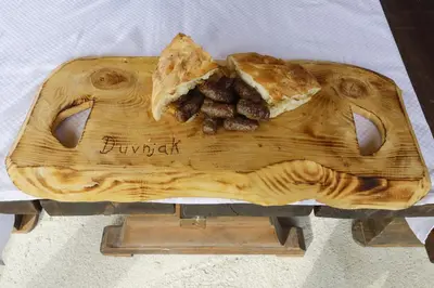 a wooden cutting board with a piece of food on it at Village house Iva in Livno