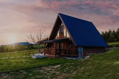 a log cabin with a blue roof on a hill at Village house Iva in Livno