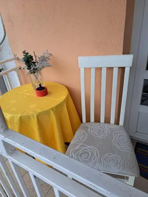 a table with a yellow table cloth and a chair at Apartman River in Prijedor