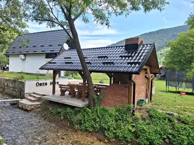 a house with a picnic table and a tree at Oaza mira 1 in Jajce