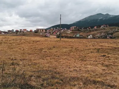 a field with a town on top of a hill at Apartment Kupres in Kupres