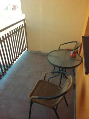 a glass table and two chairs in a room at Apartment Kupres in Kupres