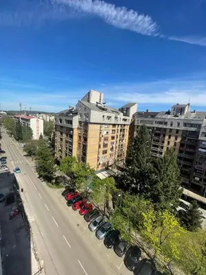 a city street with cars parked in a parking lot at Alex apartment in Banja Luka