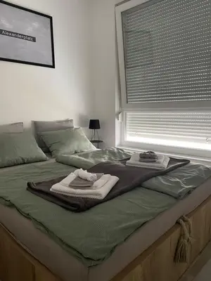 a bed with towels on it with a window at Alex apartment in Banja Luka