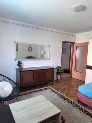 a living room with a bed and a mirror at Central13 App 3 in Tuzla