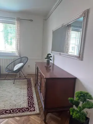 a living room with a dresser and a chair and window at Central13 App 3 in Tuzla