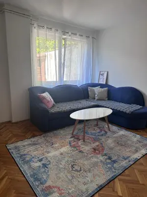 a living room with a blue couch and a table at Central13 App 3 in Tuzla