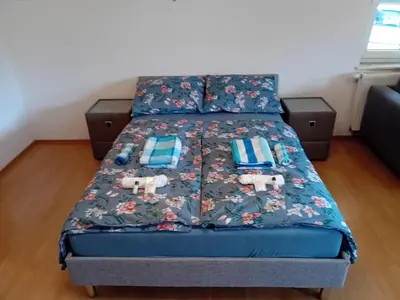 a bed with a blue comforter and pillows on it at Family Apartment Miki in Teslic in Teslić